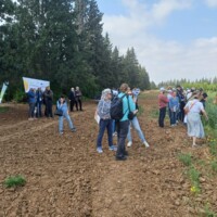 zgromadzenie ludzi na krawędzi pola uprawnego rośliny CARINATA